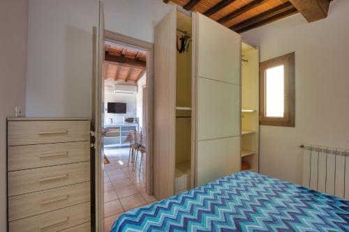 a bedroom with a bed and a door to a kitchen at La Casina di Alan - Goelba in Porto Azzurro