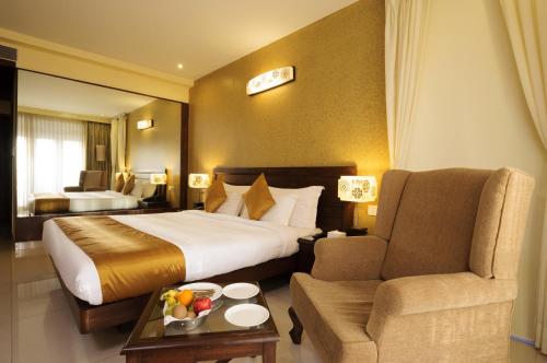 a hotel room with a bed and a chair at Varanda Do Mar in Panaji
