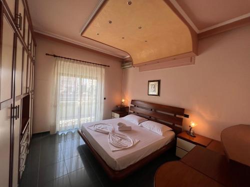 a bedroom with a bed and a large window at Green Garden Villa in Durrës