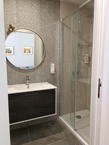a bathroom with a sink and a shower with a mirror at Quinta dos Tojais Hotel Rural in Celorico de Basto