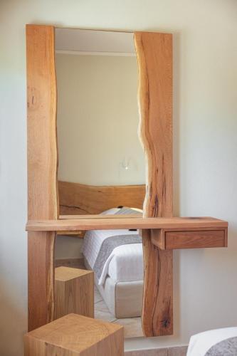 a wooden shelf with a mirror in a bedroom at PENNY LUXURY APARTMENTS in Kokkari
