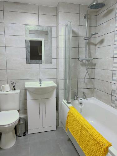 a bathroom with a toilet and a sink and a bath tub at Mayflower 3 Bedrooms House 7 Beds 2 Showers Off Road Parking in Barnsley