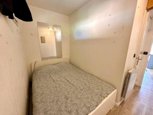 une petite chambre avec un lit et un miroir dans l'établissement Studio avec piscine proche du centre et de la gare, à Sanary-sur-Mer