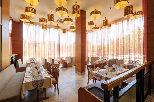 a restaurant with tables and chairs and large windows at Varanda Do Mar in Panaji