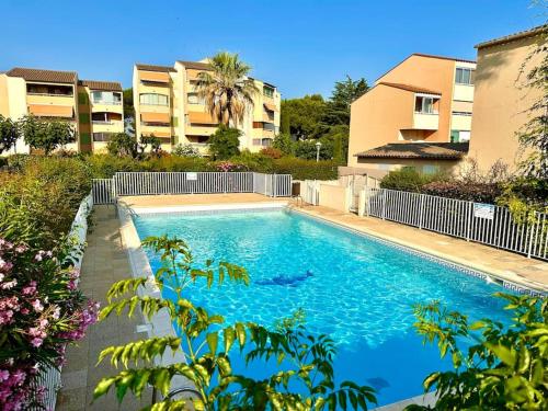une piscine devant certains immeubles d'habitation dans l'établissement Studio avec piscine proche du centre et de la gare, à Sanary-sur-Mer