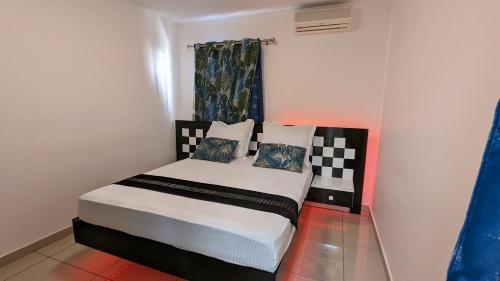 a small bedroom with a bed in a room at Appartement TUWA in Koungou