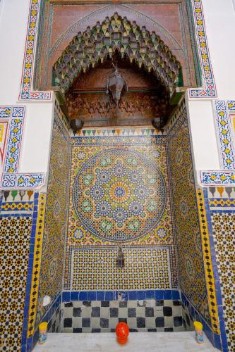 a room with a colorful tile wall with a ceiling at Riad Sahraui in Fès