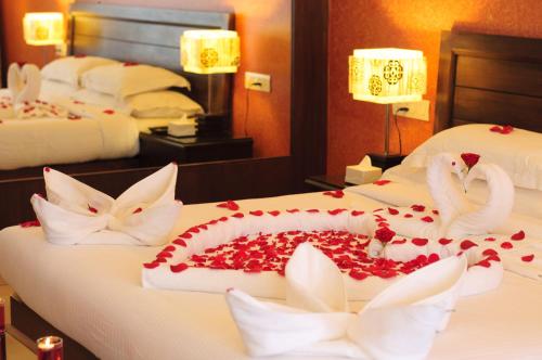 a hotel room with two beds with swans made out of roses at Varanda Do Mar in Panaji