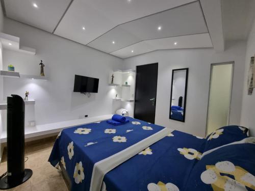 ein Schlafzimmer mit einem blauen Bett mit blauer Decke in der Unterkunft Hospedaje Casa Leví in Cali