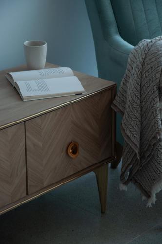 a book on a wooden table next to a chair at Seaview apartments in Ayios Elias