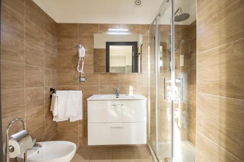 a bathroom with a toilet and a sink and a shower at Royal Playa Suite and Apartament -private parking- self chek out in Catania