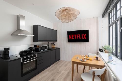 a kitchen with black cabinets and a wooden table at Contemporary First Floor Apartment Central Penzance in Penzance