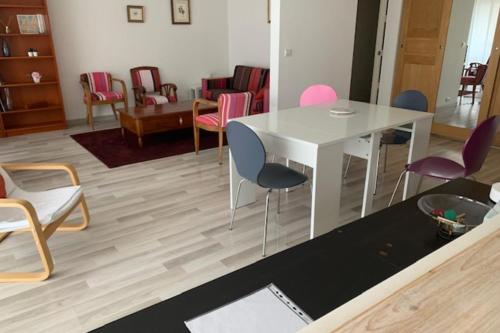 un salon avec une table et des chaises blanches dans l'établissement Spacious cocoon near the Place de la Nation, à Paris