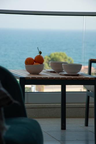 a table with two bowls of oranges on it at Seaview apartments in Ayios Elias