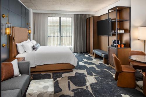 una camera d'albergo con letto e divano di The Trade, Autograph Collection a Milwaukee