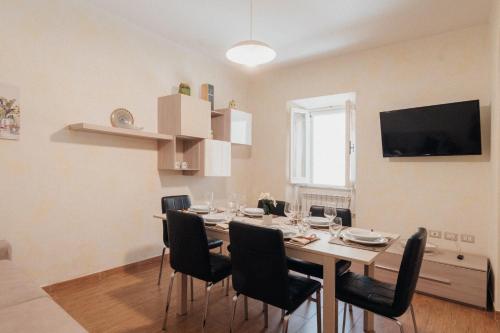 拉戈堡的住宿－Appartamento del Corso，一间带桌椅和电视的用餐室