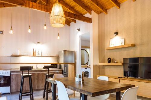 Una cocina con una mesa de madera y sillas blancas. en BOG El Sureño, en Villa La Angostura