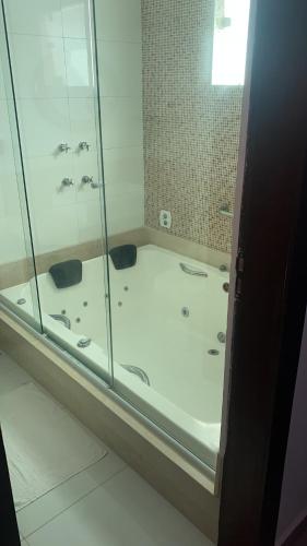 ein Bad mit einer Dusche und einer Glastür in der Unterkunft Mansão Bolsoni in Saquarema