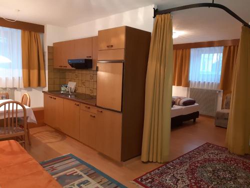 una sala de estar con cocina y una habitación con sofá en Residence Haus Peder en Solda