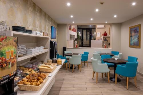 un restaurant avec des chaises bleues, une table et un comptoir dans l'établissement The Originals Boutique, Hôtel Danieli, Avignon, à Avignon