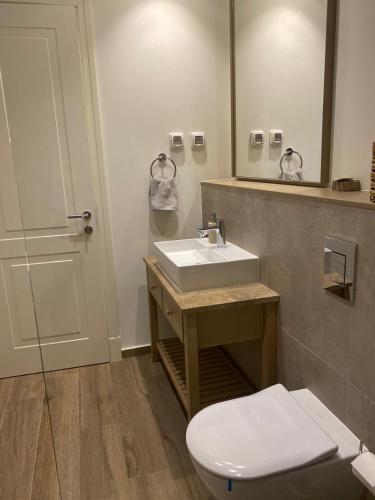 a bathroom with a sink and a toilet and a mirror at Lustica Bay Centrale Sparcle in Tivat