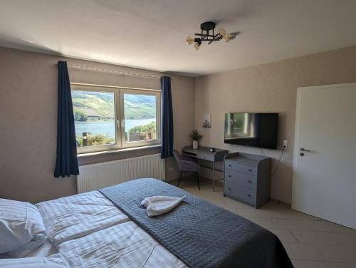 a bedroom with a bed and a desk and a window at Ferienwohnung Rheinperle in Niederheimbach