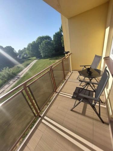 a balcony with a table and chairs on a balcony at Apartament Wrzosowe Pola in Wrzosowo