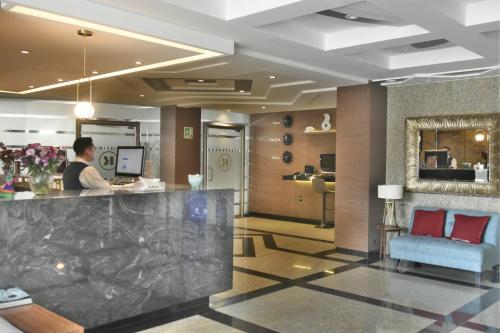 a man standing at a counter in a hotel lobby at KALI Escandón Mexico City in Mexico City