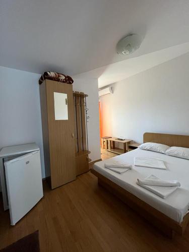 a bedroom with a bed and a wooden floor at Vila Alexa in Costinesti