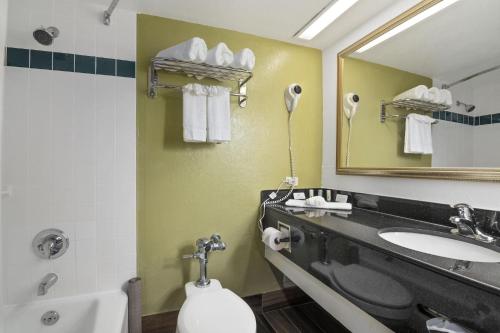 a bathroom with a sink and a toilet and a mirror at Quality Inn Airport - Cruise Port in Tampa