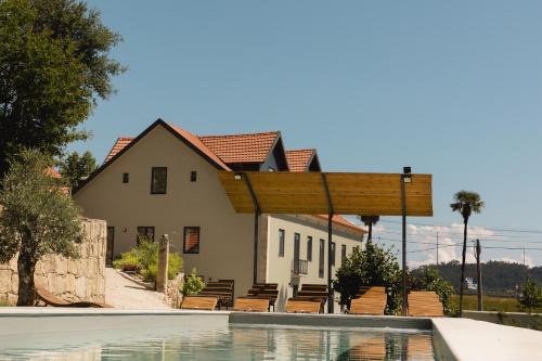 a house with a swimming pool in front of a house at Quinta dos Tojais in Celorico de Basto