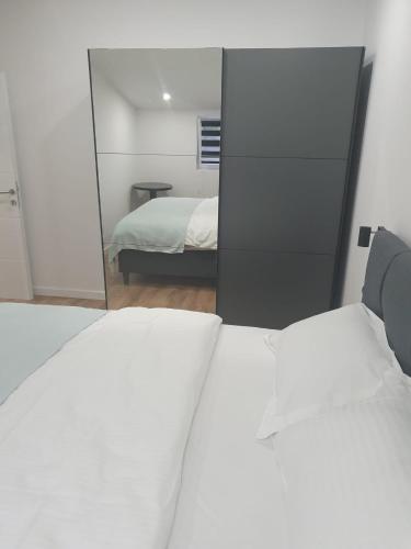 a bedroom with two beds and a mirror at MB Apartman in Čapljina