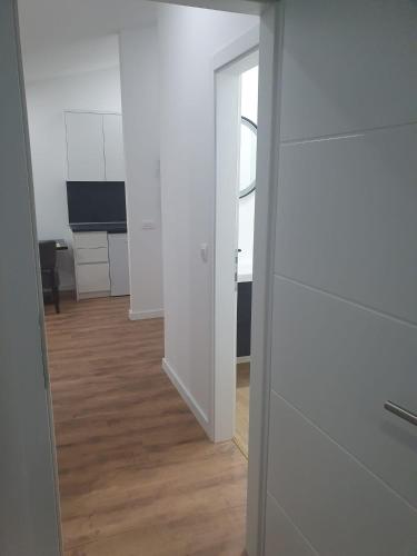 a room with white walls and a hallway with a mirror at MB Apartman in Čapljina