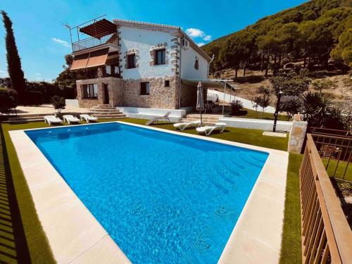 a villa with a swimming pool in front of a house at Casa Brian del Tietar in Sotillo de la Adrada
