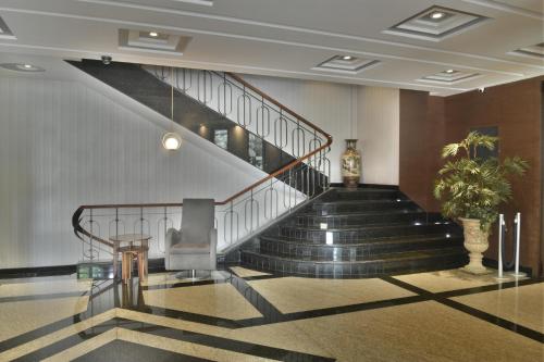 a lobby with a staircase with a potted plant at KALI Escandón Mexico City in Mexico City