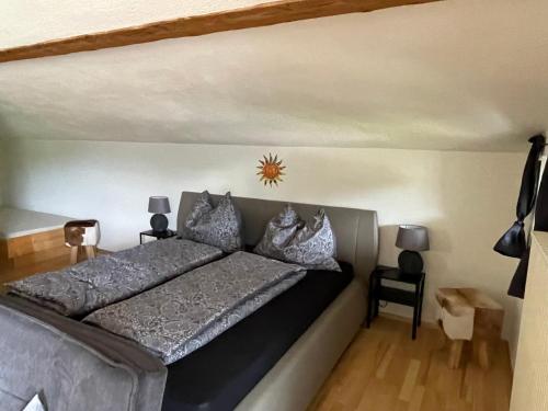 1 dormitorio con 1 cama grande con sábanas y almohadas grises en Ferienwohnung Wieser, en Sankt Jakob in Haus