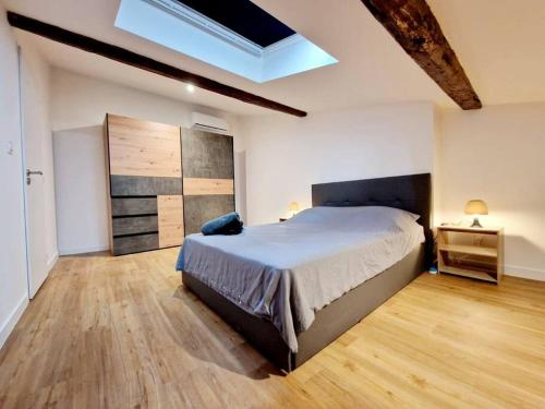 a bedroom with a large bed and a wooden floor at Appart douillet hypercentre neuf climatisé in Valence