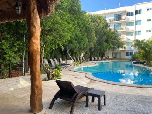 un complexe avec une piscine, des chaises et un bâtiment dans l'établissement Beach Haus-Punta Estrella, à Playa del Carmen