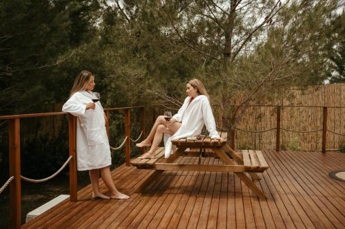 two women sitting on a picnic table on a deck at Welmoon Villas Paisaje in Caravaca de la Cruz