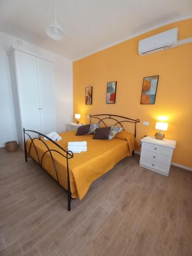 a bedroom with a bed and a yellow wall at Divina Cuspide in Guspini