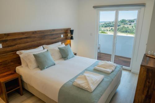 a bedroom with a large bed with a large window at Casa Dona Maria in Montargil
