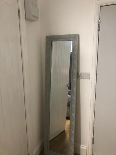 um espelho num quarto ao lado de uma porta em Modern En-suite Double Room em Newport
