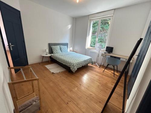 a bedroom with a bed and a desk and a window at Appartement confortable de 80m2 Centre ville de Quimper & Parking privé in Quimper