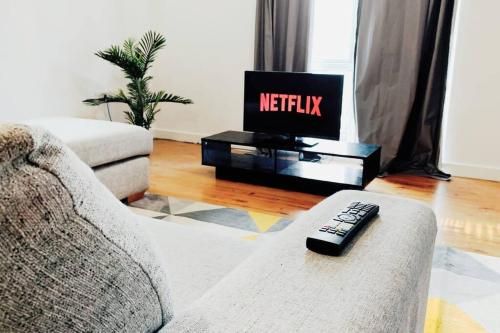 a remote control sitting on a couch in a living room at 2 Bed Apartment with Free Parking in Chelmsford