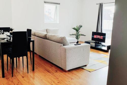 ein Wohnzimmer mit einem weißen Sofa und einem Tisch in der Unterkunft 2 Bed Apartment with Free Parking in Chelmsford