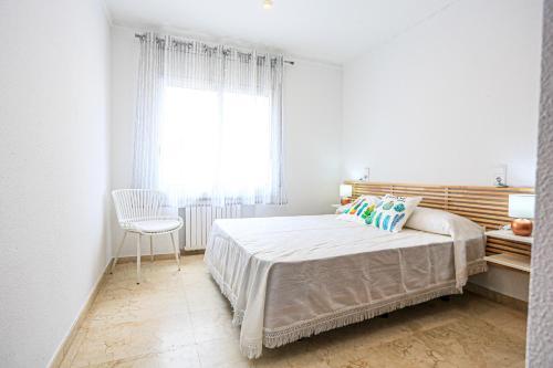 a bedroom with a bed and a window and a chair at LITORAL COSTA DORADA - AQUARIUM Only families in Cambrils