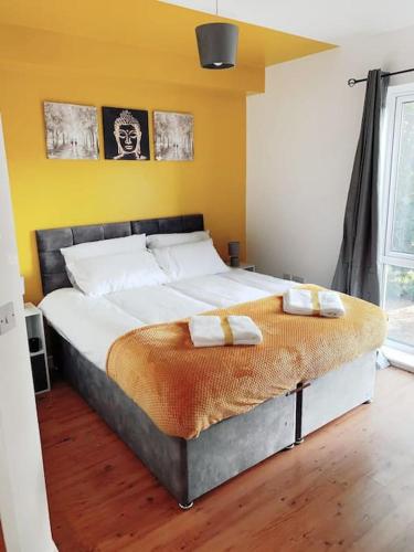 a bedroom with a large bed with two towels on it at 2 Bed Apartment with Free Parking in Chelmsford