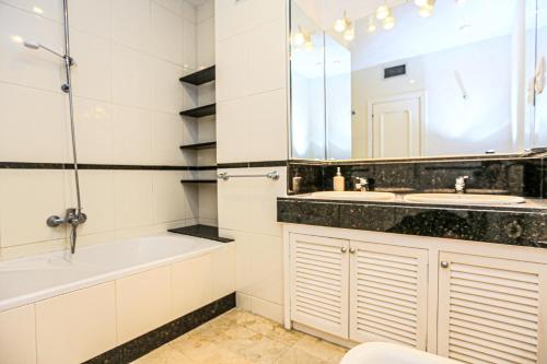a bathroom with a tub and a sink and a bath tub at LITORAL COSTA DORADA - AQUARIUM Only families in Cambrils