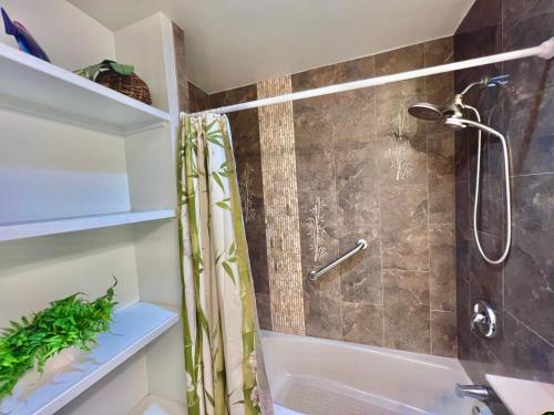 a bathroom with a shower and a tub at Maui Kamaole D208 in Wailea