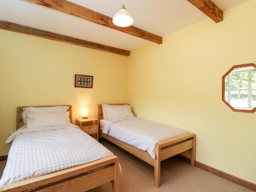 two twin beds in a room with a window at Little Barn in Chippenham